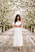 Load image into Gallery viewer, woman wearing white embroidered off shoulder maxi dress cherry blossoms spring fashion look