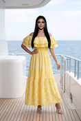 Load image into Gallery viewer, woman wearing yellow floral off shoulder maxi dress on beach summer vacation outfit