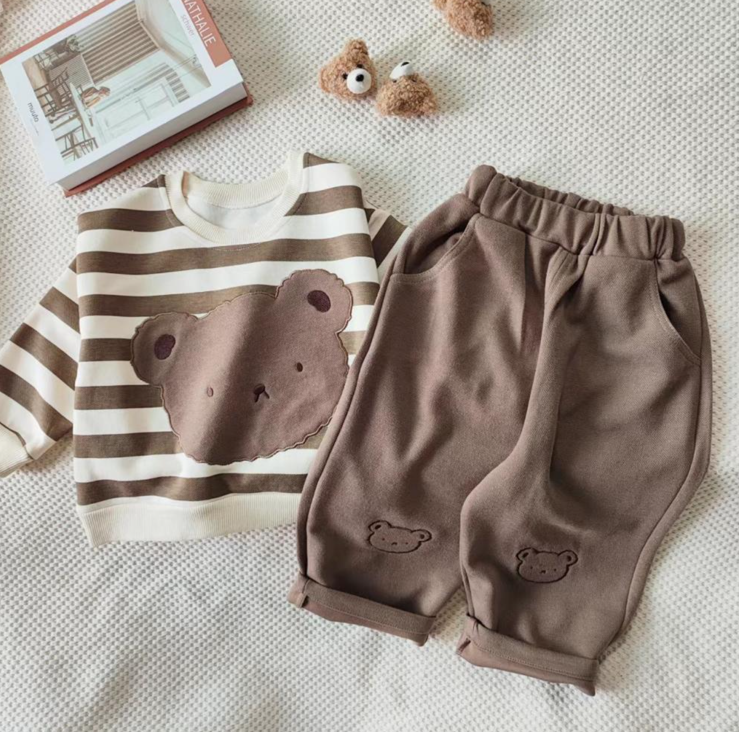 1 super cozy Top featuring a large Baby Bear face, showcasing your little one's love for bears, and 1 comfy pair of Pants with Bear patches at the knees, adding a playful touch to their outfit.