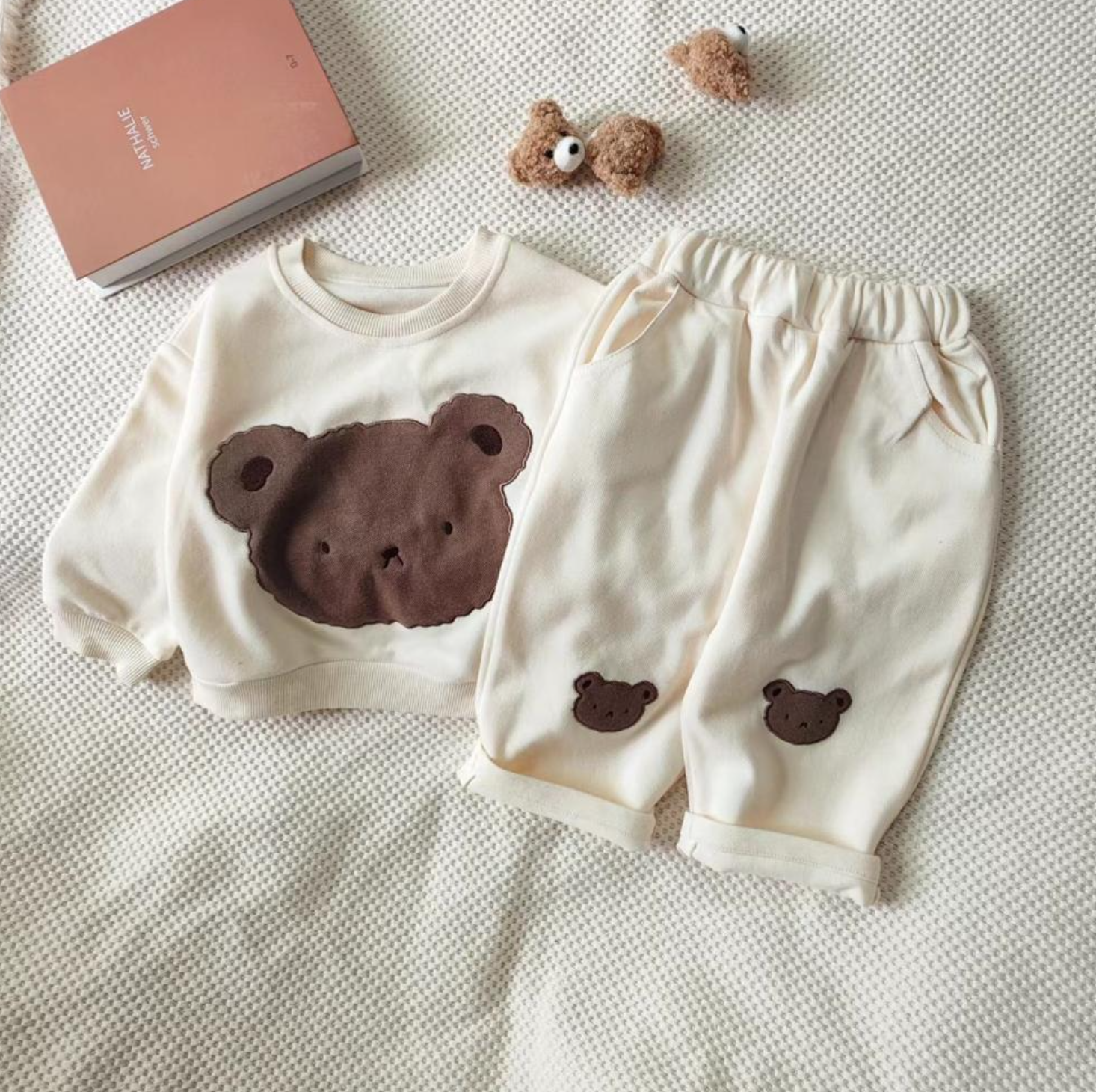 1 super cozy Top featuring a large Baby Bear face, showcasing your little one's love for bears, and 1 comfy pair of Pants with Bear patches at the knees, adding a playful touch to their outfit.