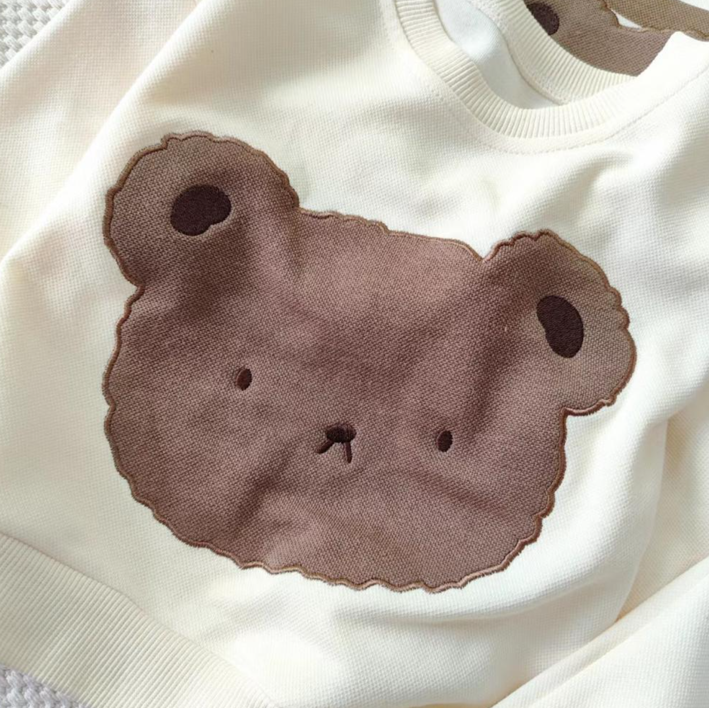 1 super cozy Top featuring a large Baby Bear face, showcasing your little one's love for bears, and 1 comfy pair of Pants with Bear patches at the knees, adding a playful touch to their outfit.