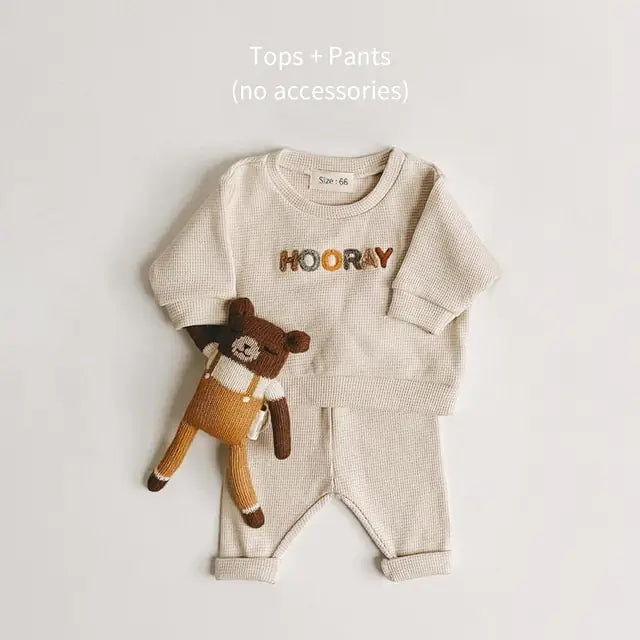 Kyle Unisex Spring Baby 2 Piece Sweatsuit Set. This dynamic duo features an adorable long-sleeved sweatshirt paired with cozy pants, giving your little one an instant dose of charm.